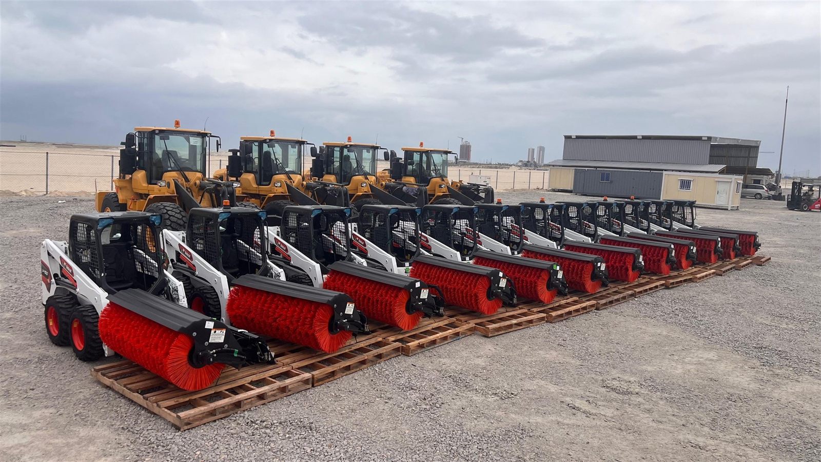 Bobcat skid steer loaders with sweeper attachments arranged at the plant yard