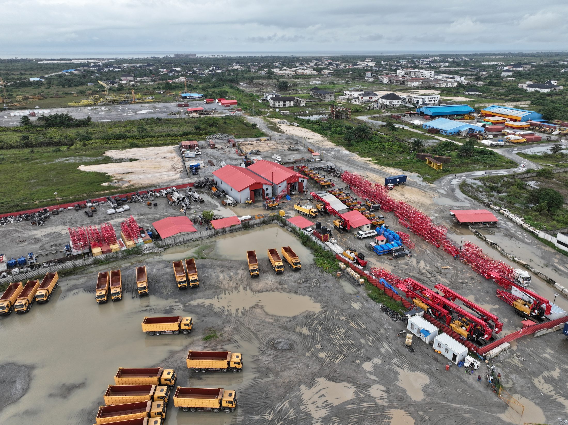 Concrete boom pump trucks parked alongside tipper trucks at the Lekki yard