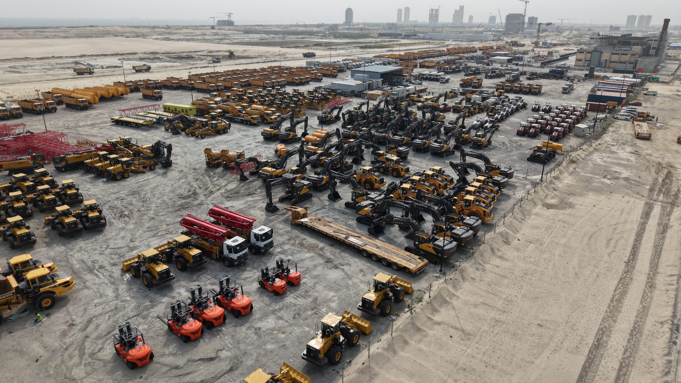 Wide panorama of the main equipment yard with excavators, dozers, forklifts and dump trucks