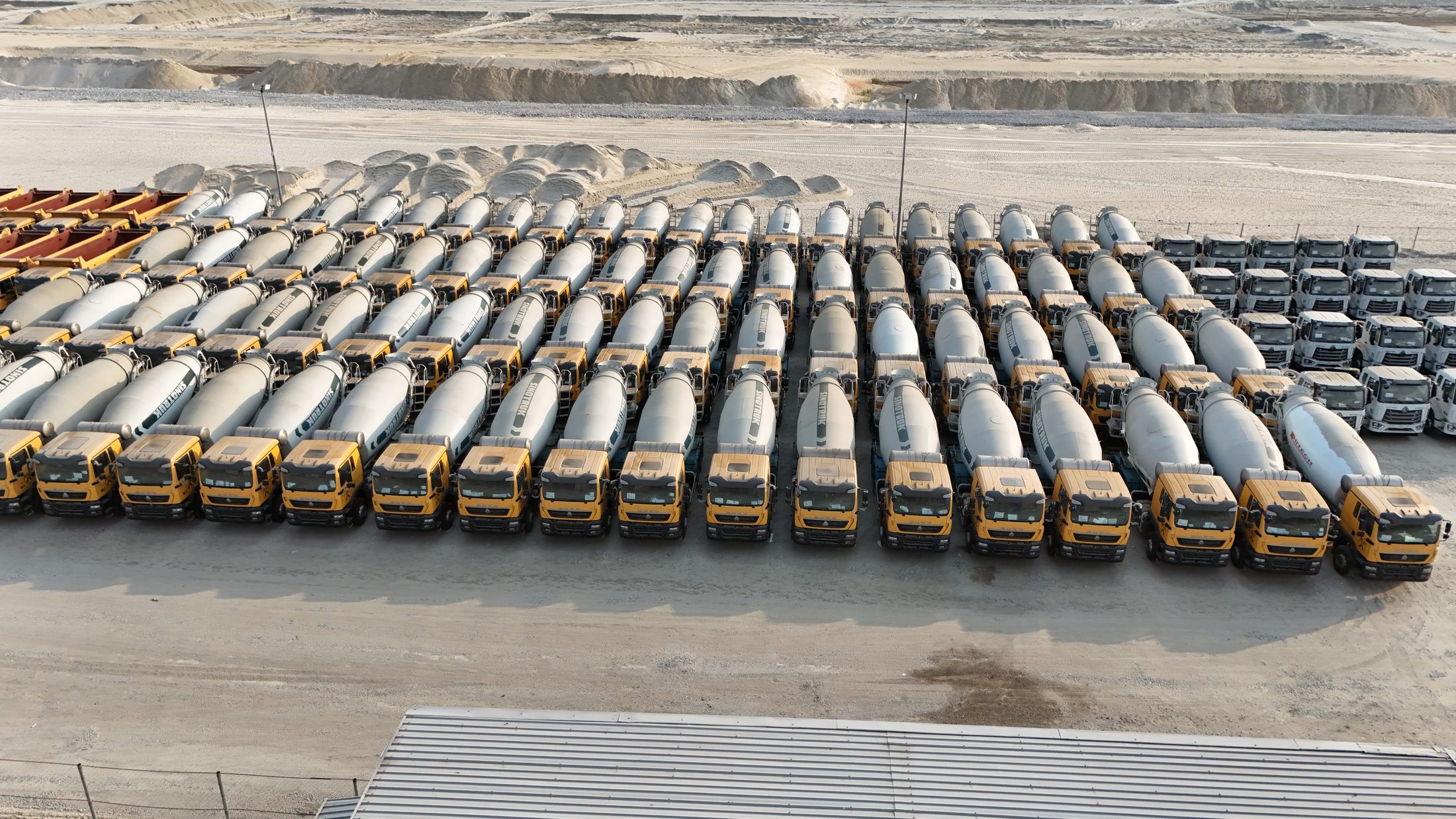 Aerial view of Hitech concrete mixer trucks arranged in converging rows across the mixer depot