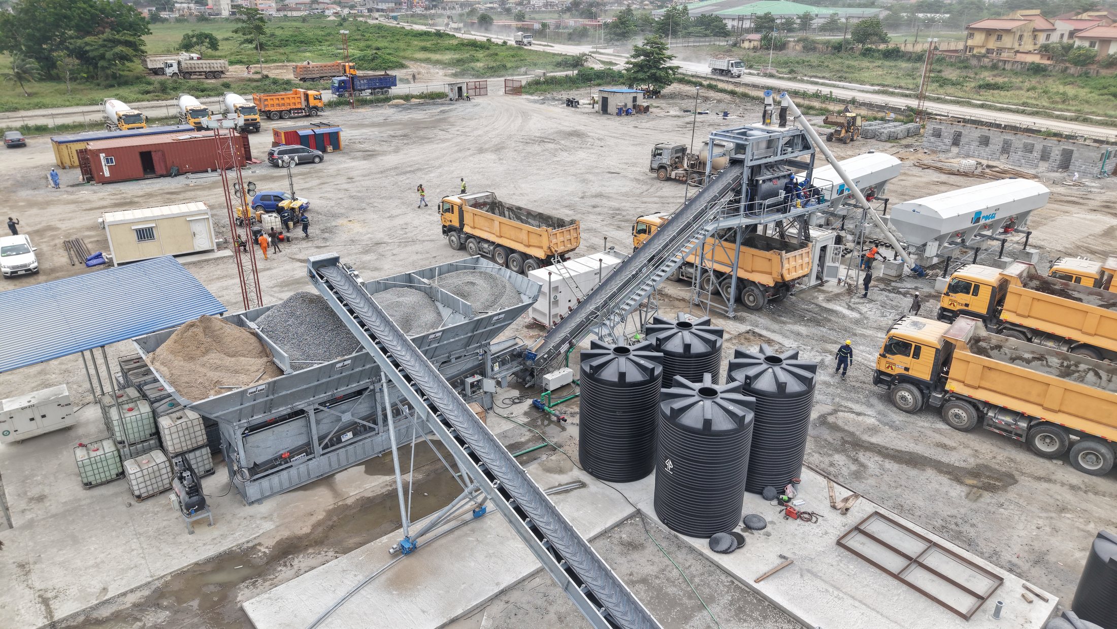 Mobile concrete batching plant with conveyors and mixer trucks in operation