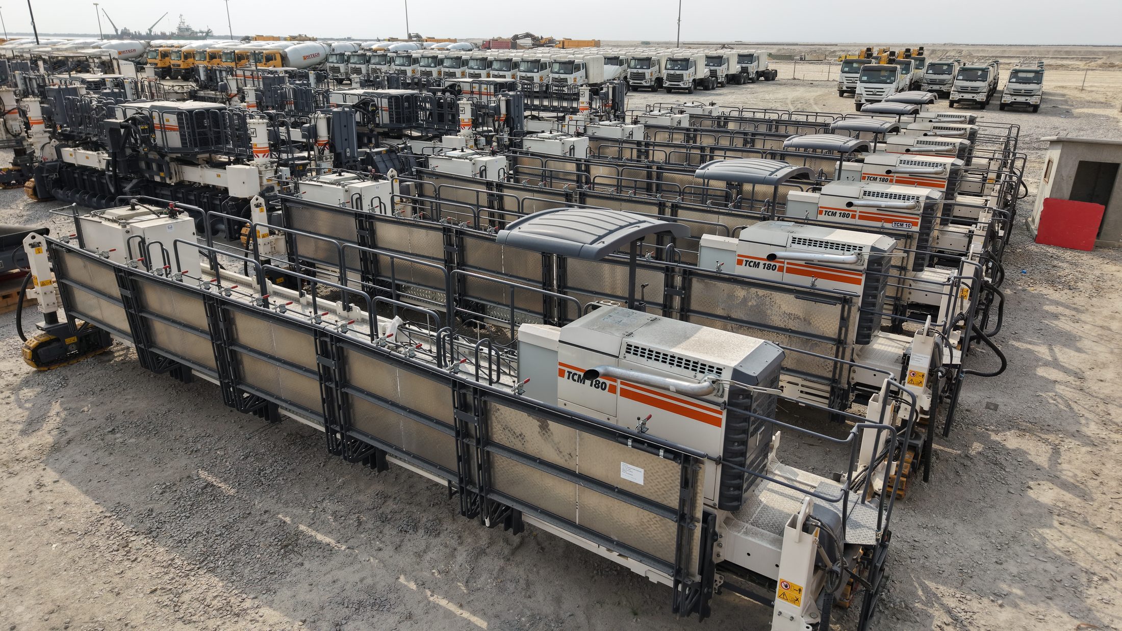 Wirtgen TCM 180 slipform trimmers arranged in rows at the plant yard