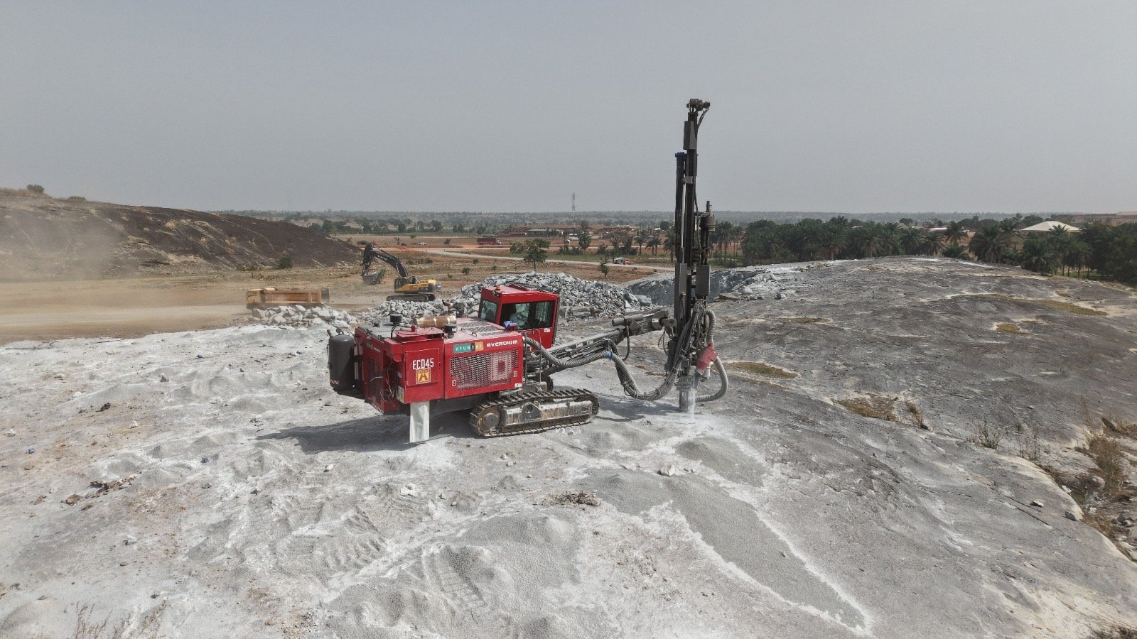 Drilling rig preparing a granite rock surface at a quarry site