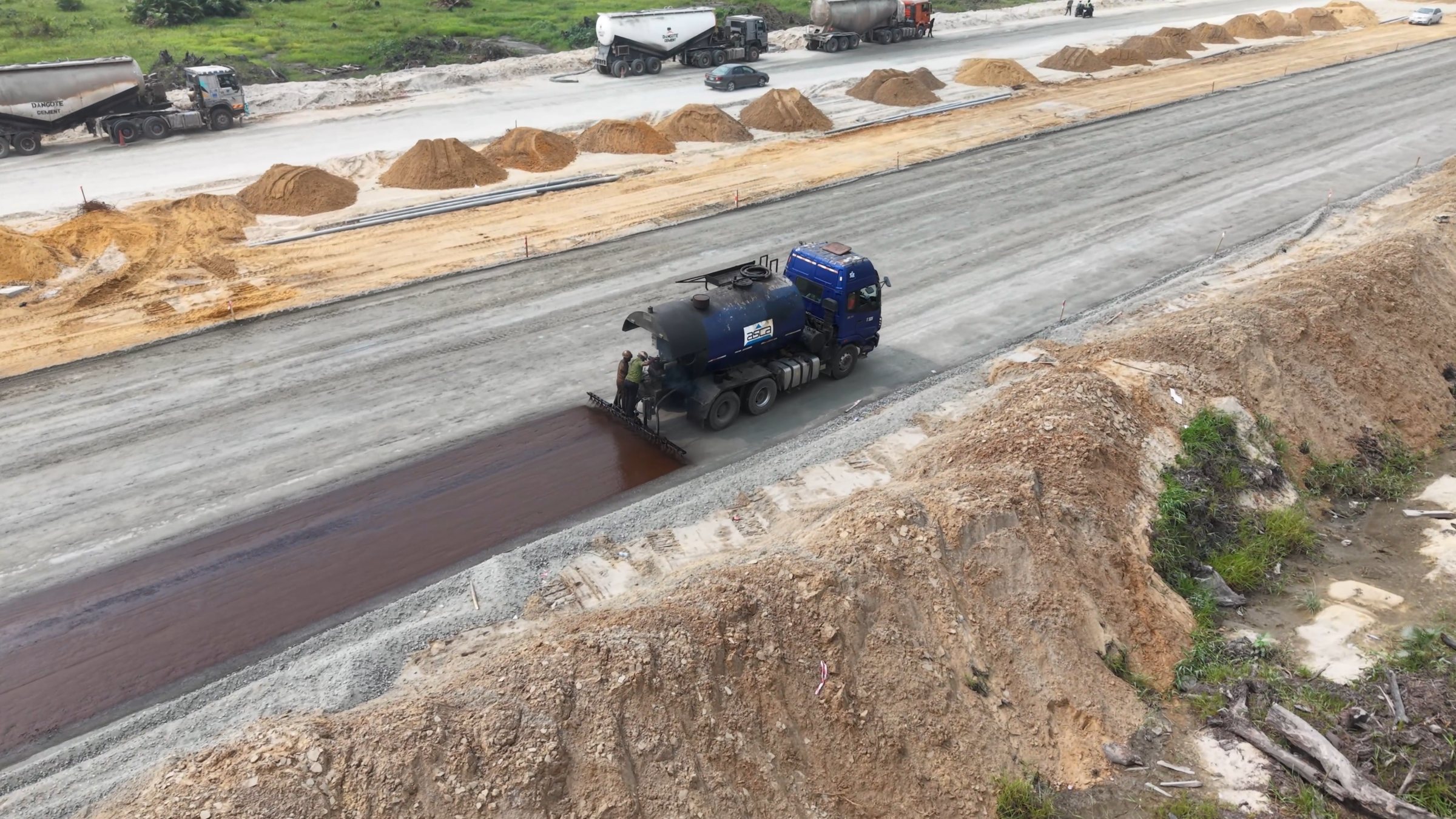 Close aerial view of bitumen priming application on a road corridor