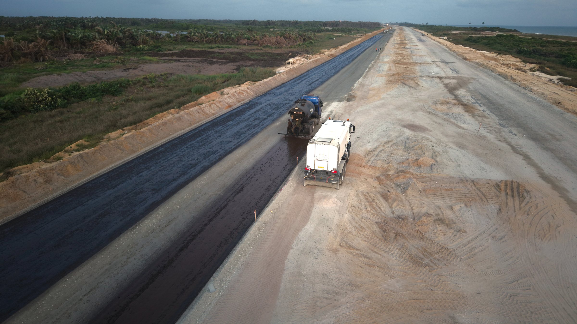 Bitumen priming works progressing along a prepared highway corridor